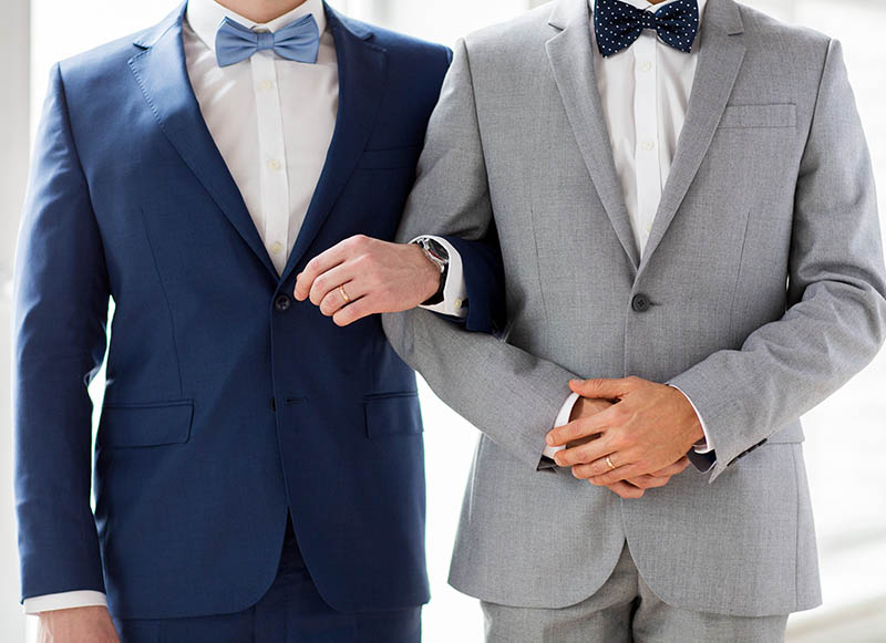two men in suits and bowties, one blue one grey.