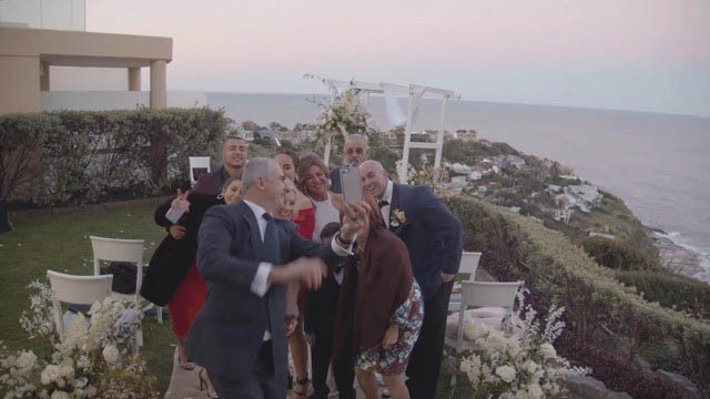 group of people taking selfie at wedding 