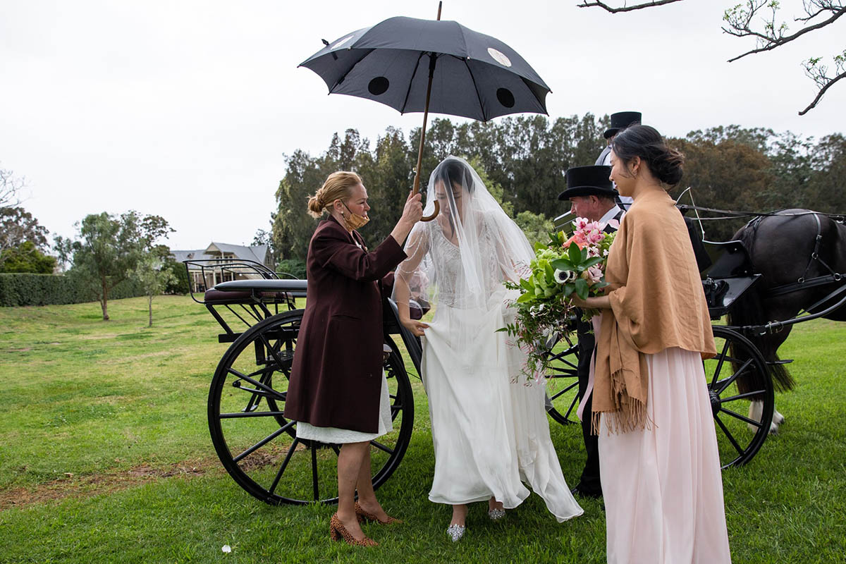 Bride under umbrella - celebrant and wedding planning services @luxeunforgettableevents